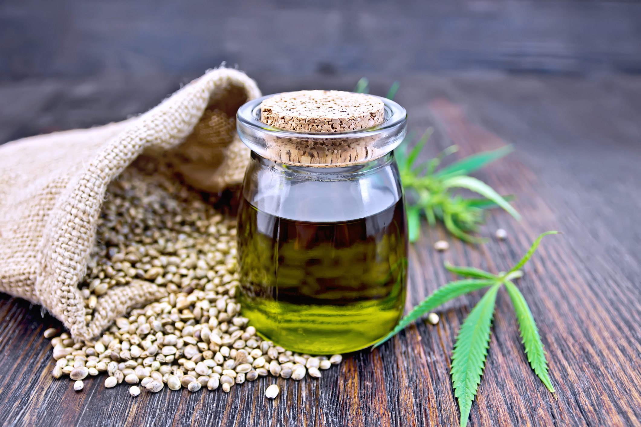 Glass jar with hemp oil and seeds.