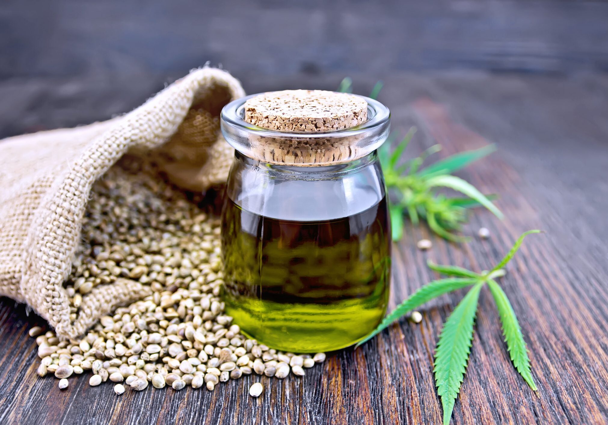 Glass jar with hemp oil and seeds.